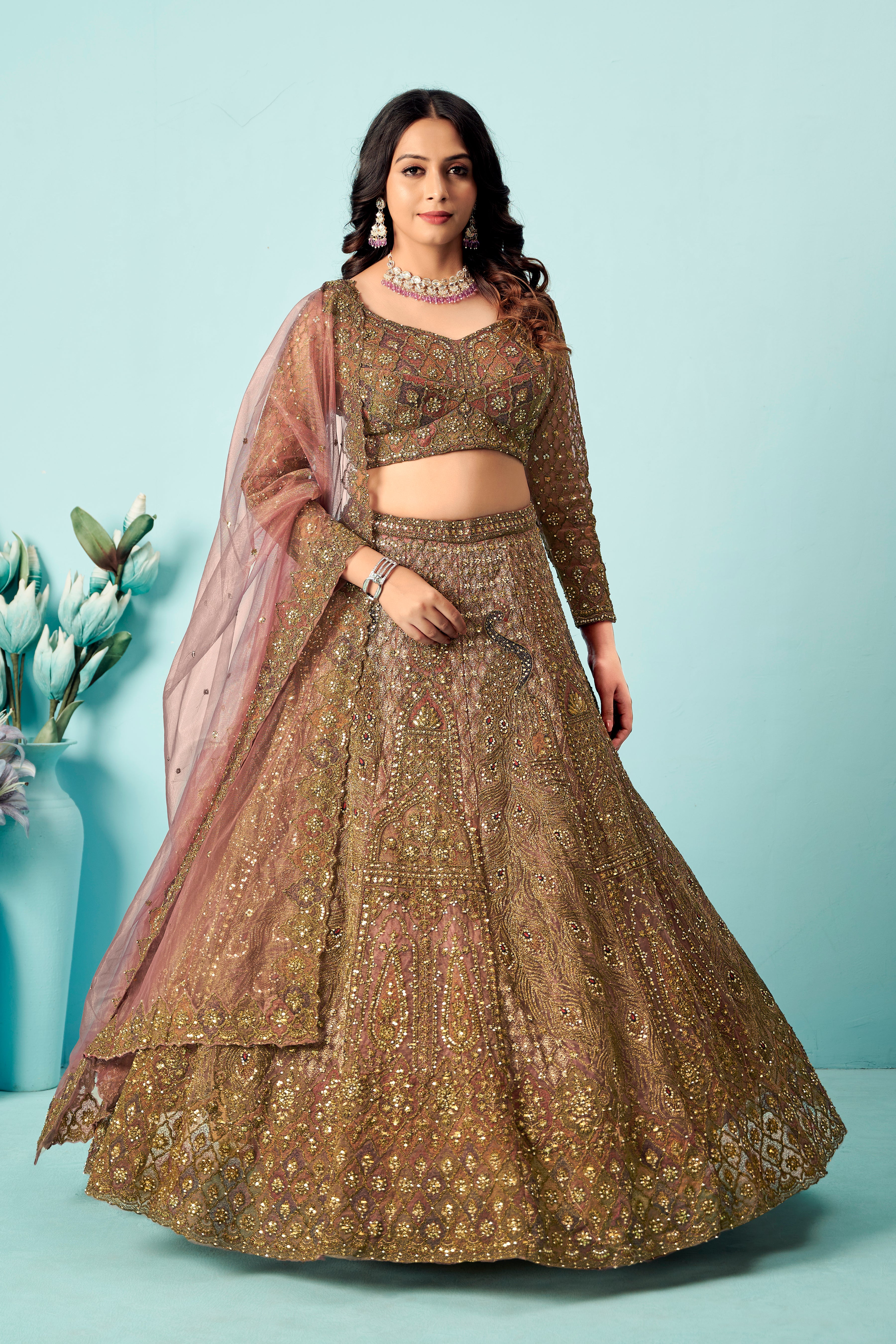 Antique rose-gold heavy embroidered lehenga set with matching blouse and net dupatta.