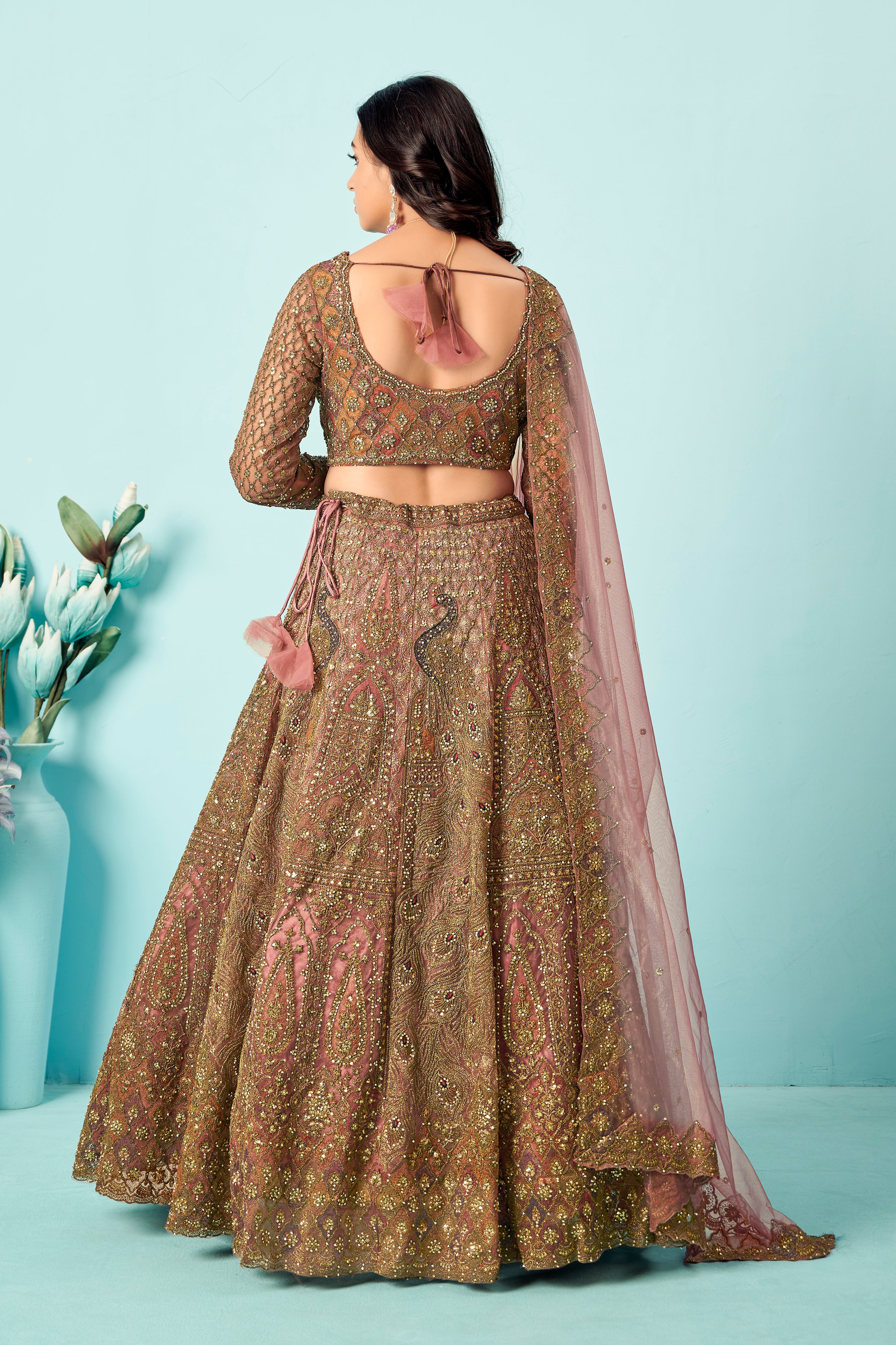 Antique rose-gold heavy embroidered lehenga set with matching blouse and net dupatta.